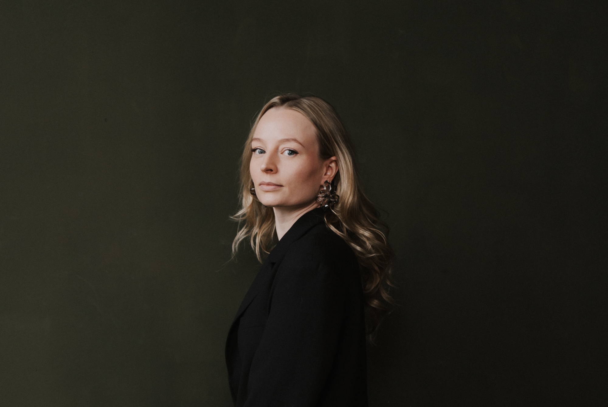 Kyra Berger, portrait on a dark backdrop